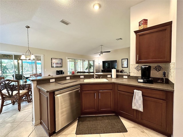 kitchen with visible vents, dark countertops, a sink, open floor plan, and stainless steel dishwasher