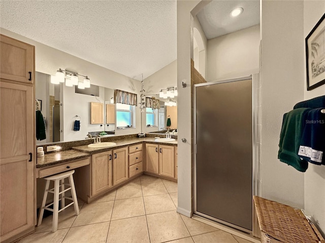 bathroom with tile patterned flooring, a textured ceiling, a sink, a stall shower, and double vanity
