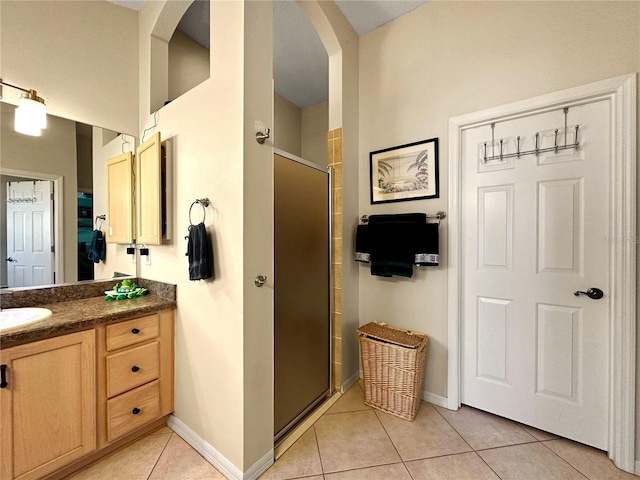 full bath with tile patterned floors, vanity, a stall shower, and baseboards