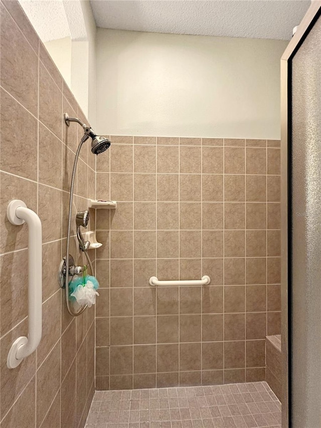 bathroom with a textured ceiling and a shower stall