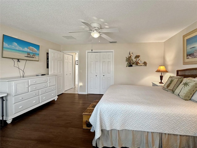bedroom featuring a textured ceiling, visible vents, a closet, ceiling fan, and wood finished floors