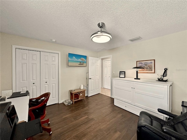 office area featuring a textured ceiling, visible vents, and dark wood finished floors