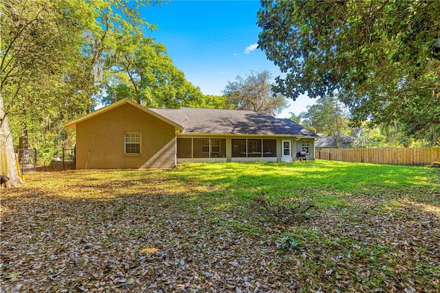 2922 SE 39th Pl, Ocala, FL 34480 - rear view of house with a lawn, a sunroom, a fenced backyard, and stucco siding