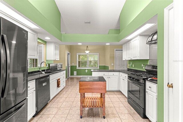 2922 SE 39th Pl, Ocala, FL 34480 - kitchen featuring black gas stove, dark countertops, a sink, dishwashing machine, and freestanding refrigerator