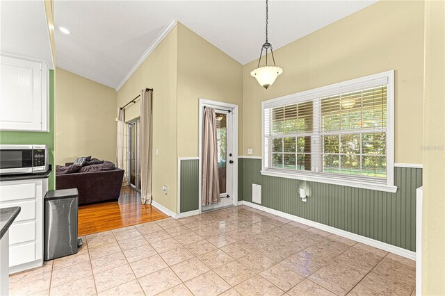 2922 SE 39th Pl, Ocala, FL 34480 - foyer with crown molding, lofted ceiling, light tile patterned floors, a wainscoted wall, and wooden walls