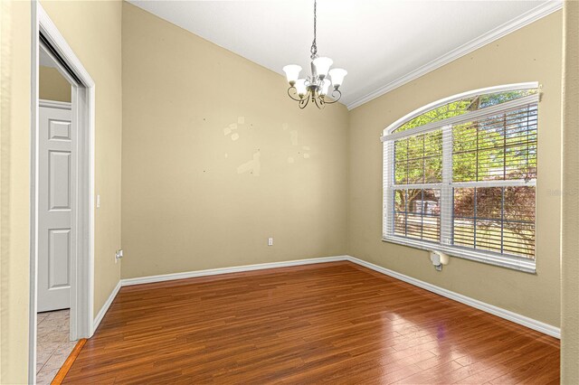 2922 SE 39th Pl, Ocala, FL 34480 - empty room featuring baseboards, wood-type flooring, ornamental molding, and a chandelier