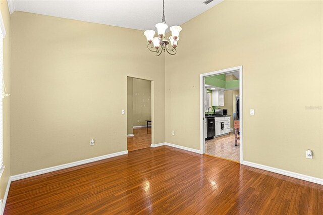 2922 SE 39th Pl, Ocala, FL 34480 - spare room with a notable chandelier, high vaulted ceiling, baseboards, and light wood-type flooring