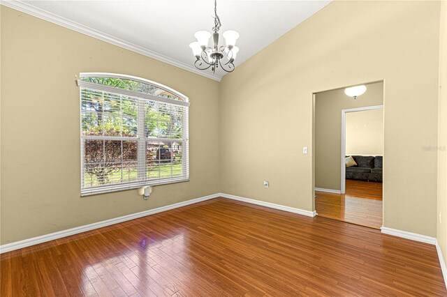 2922 SE 39th Pl, Ocala, FL 34480 - spare room with hardwood / wood-style flooring, baseboards, ornamental molding, an inviting chandelier, and vaulted ceiling