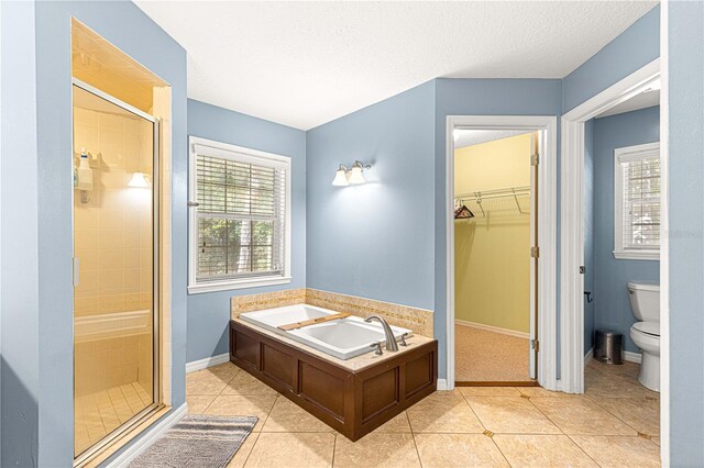 2922 SE 39th Pl, Ocala, FL 34480 - full bathroom featuring a shower stall, toilet, tile patterned floors, a garden tub, and a walk in closet