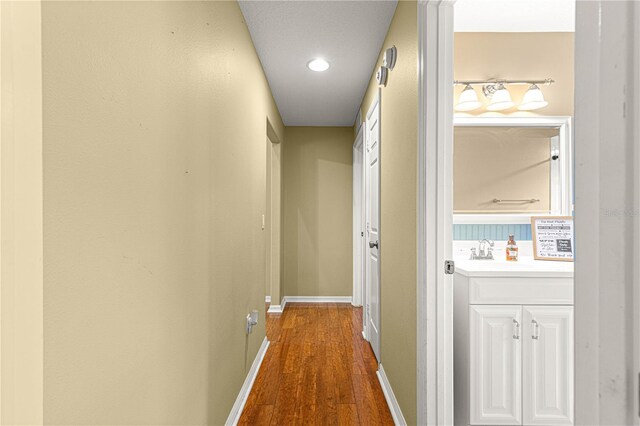 2922 SE 39th Pl, Ocala, FL 34480 - corridor featuring baseboards, dark wood-type flooring, and a sink
