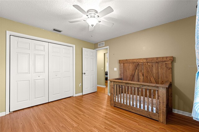 2922 SE 39th Pl, Ocala, FL 34480 - bedroom featuring wood finished floors, a textured ceiling, a closet, and visible vents