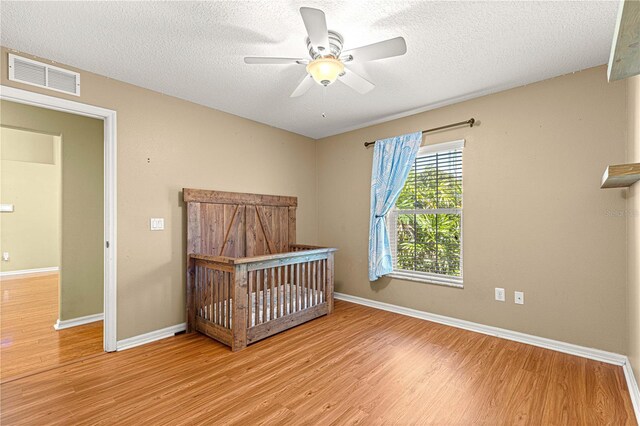 2922 SE 39th Pl, Ocala, FL 34480 - unfurnished bedroom featuring baseboards, visible vents, wood finished floors, and a textured ceiling