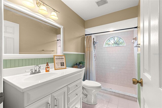 2922 SE 39th Pl, Ocala, FL 34480 - bathroom featuring vanity, a tile shower, toilet, a wainscoted wall, and visible vents