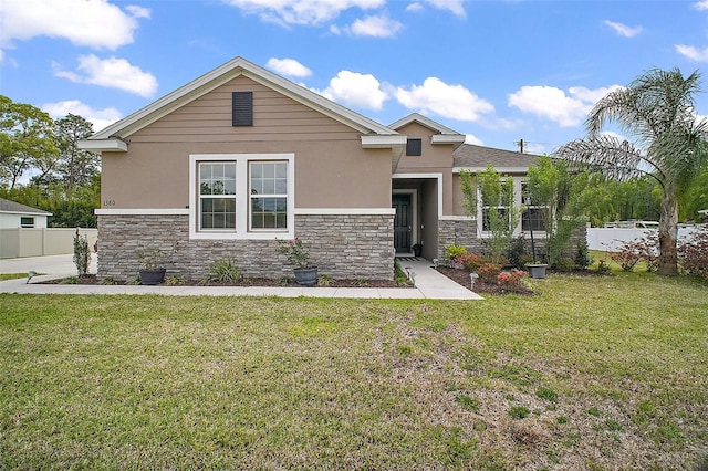 view of front of house featuring stone siding, stucco siding, and a front lawn