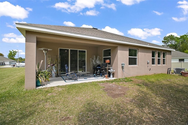 back of house featuring a patio, a lawn, roof with shingles, stucco siding, and cooling unit