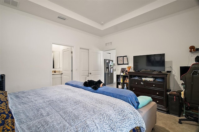 carpeted bedroom featuring visible vents, stainless steel refrigerator with ice dispenser, and a raised ceiling