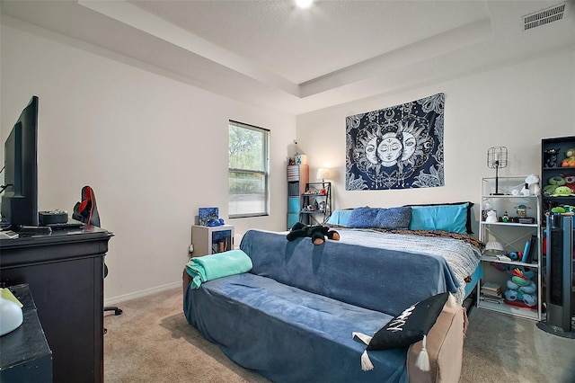 carpeted bedroom with a raised ceiling, baseboards, and visible vents