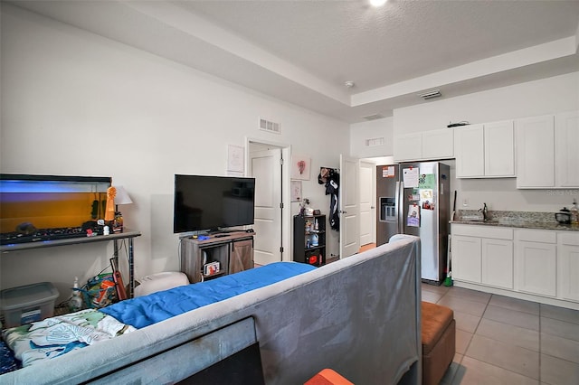 tiled living area featuring visible vents and a textured ceiling
