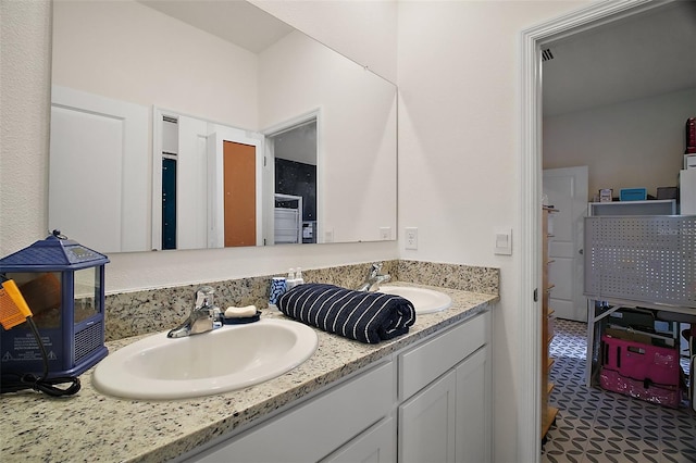 full bathroom with double vanity and a sink