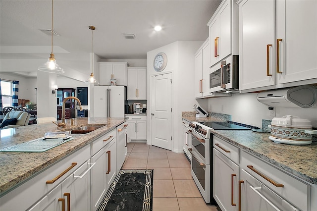 kitchen with white cabinets, visible vents, stainless steel microwave, a sink, and range with two ovens