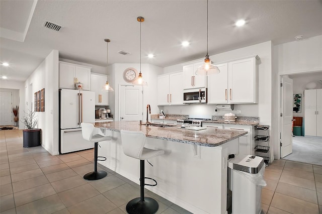 kitchen featuring light tile patterned flooring, visible vents, a sink, and freestanding refrigerator