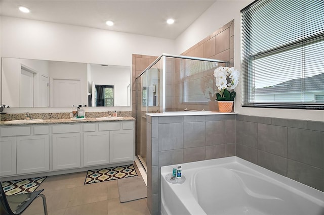 bathroom featuring a bath, double vanity, a sink, and a stall shower
