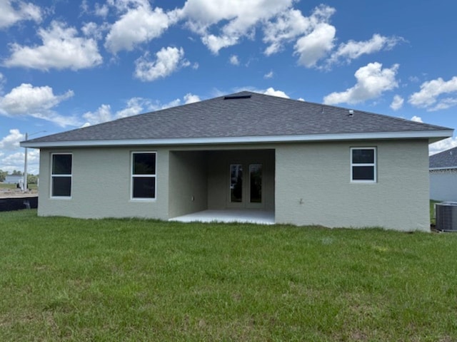 2166 NW 23rd Loop, Ocala, FL 34475 - back of house with a patio, a lawn, central AC, and a shingled roof