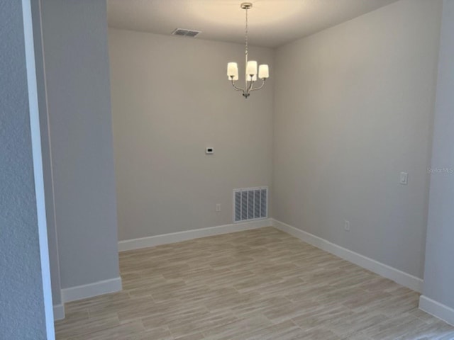 2166 NW 23rd Loop, Ocala, FL 34475 - unfurnished room with light wood-style flooring, a chandelier, and baseboards