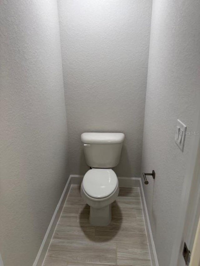 2166 NW 23rd Loop, Ocala, FL 34475 - bathroom with baseboards, toilet, and a textured wall