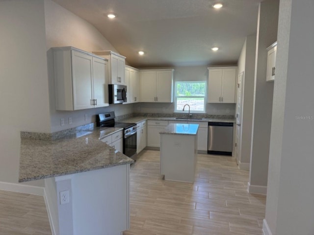 2166 NW 23rd Loop, Ocala, FL 34475 - kitchen with stainless steel appliances, a peninsula, baseboards, a sink, and light wood finished floors