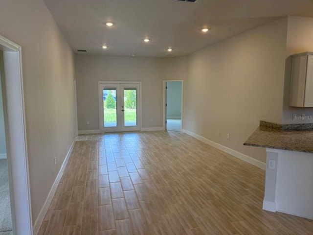2166 NW 23rd Loop, Ocala, FL 34475 - unfurnished living room featuring light wood-style flooring, recessed lighting, baseboards, and french doors