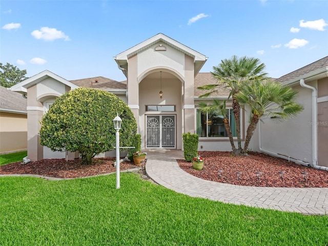 exterior space with stucco siding and a lawn