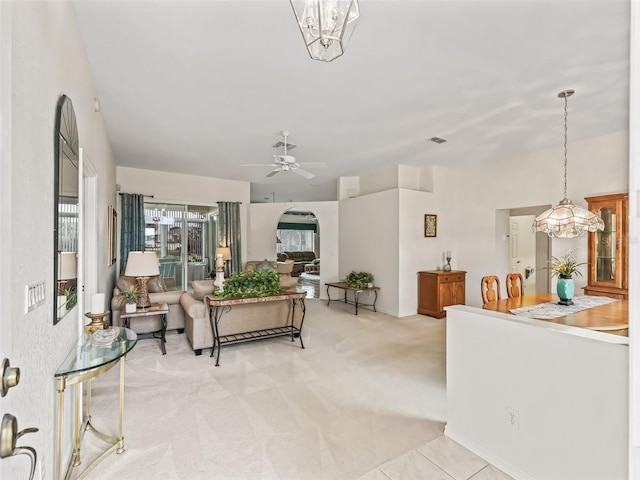 living room with light carpet and ceiling fan with notable chandelier