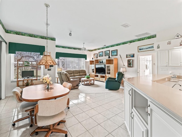 dining space featuring light tile patterned floors, ceiling fan, and visible vents