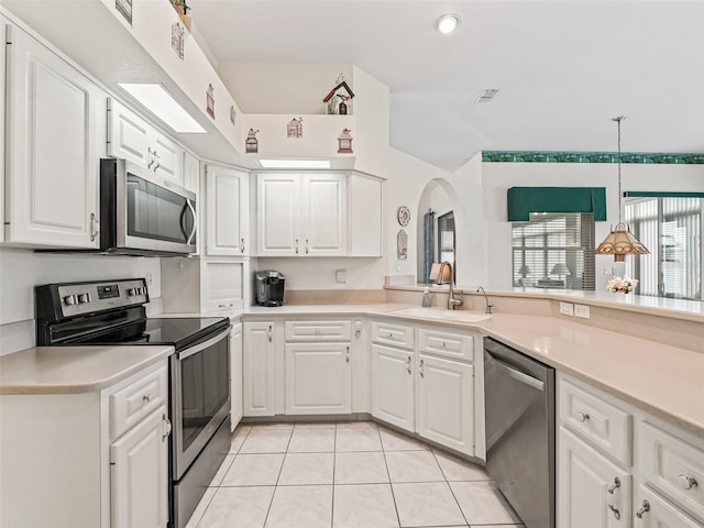 kitchen with light countertops, white cabinets, stainless steel appliances, a sink, and light tile patterned floors