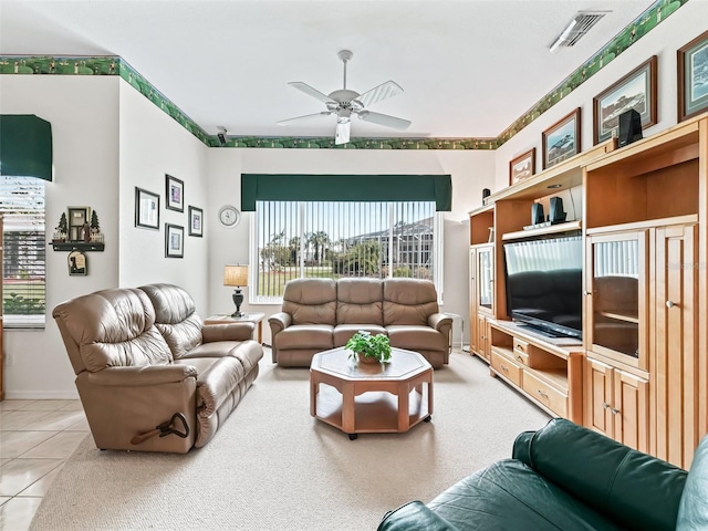 living room featuring light tile patterned flooring, visible vents, and a ceiling fan