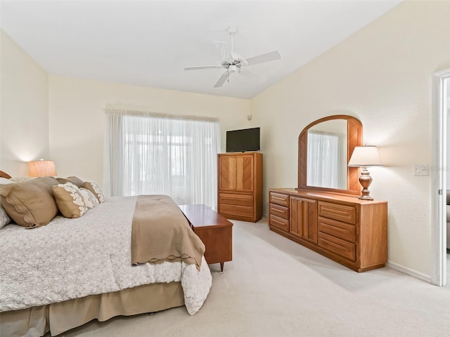 bedroom featuring light carpet, baseboards, lofted ceiling, and ceiling fan
