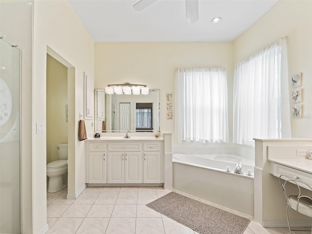 full bathroom featuring tile patterned floors, vanity, a ceiling fan, a healthy amount of sunlight, and a garden tub