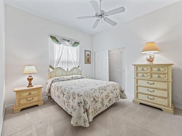 bedroom featuring light colored carpet, a closet, and a ceiling fan