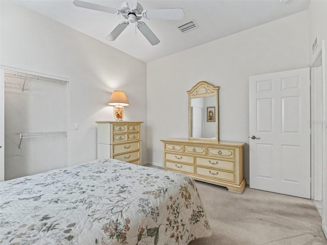 bedroom with light carpet, visible vents, a closet, and a ceiling fan