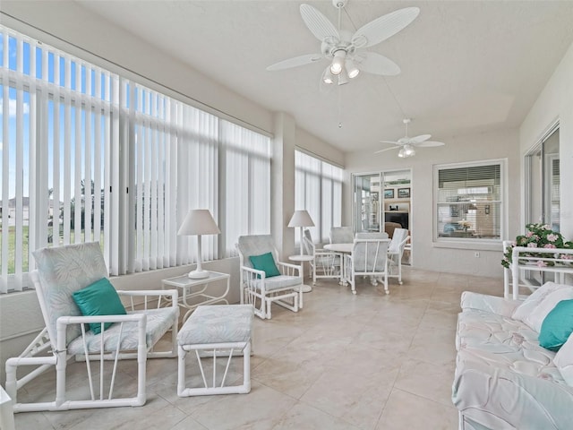 sunroom / solarium with a ceiling fan and outdoor dining area