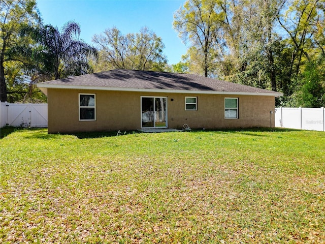 4575 SE 137th Pl, Summerfield, FL 34491 - back of house with a fenced backyard, a gate, stucco siding, and a yard