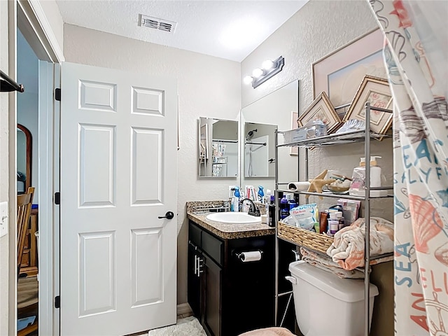 4575 SE 137th Pl, Summerfield, FL 34491 - full bath with toilet, vanity, a textured ceiling, visible vents, and a textured wall