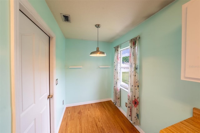 unfurnished dining area with baseboards, visible vents, and light wood-style floors