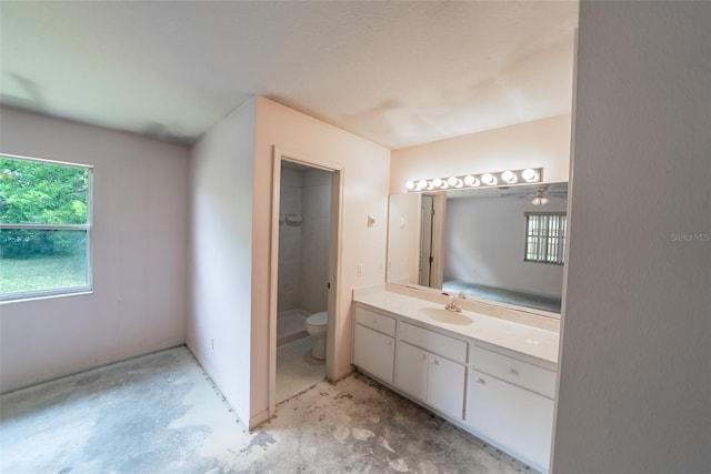 full bath featuring plenty of natural light, toilet, vanity, and concrete flooring