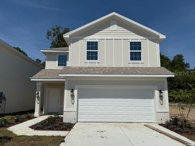 2218 NW 23rd Loop, Ocala, FL 34475 - traditional home with roof with shingles, an attached garage, and driveway