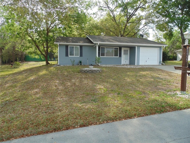 ranch-style house featuring an attached garage, concrete driveway, and a front yard