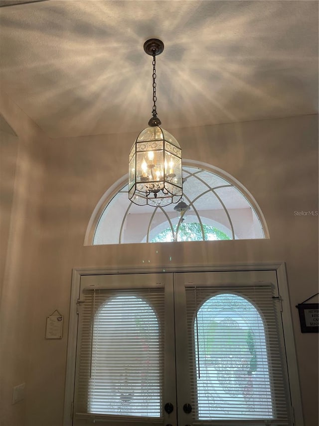 room details with french doors and an inviting chandelier