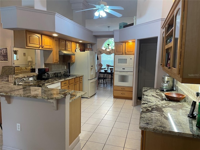 kitchen featuring light tile patterned flooring, a ceiling fan, a peninsula, under cabinet range hood, and white appliances