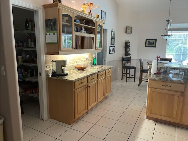 kitchen with tasteful backsplash, stone countertops, open shelves, hanging light fixtures, and light tile patterned floors